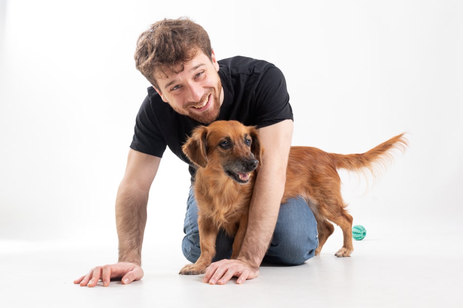 Àlex sonriendo junto a su perro en una sesión de fotos en estudio, un recuerdo especial de Mascotes de Colors